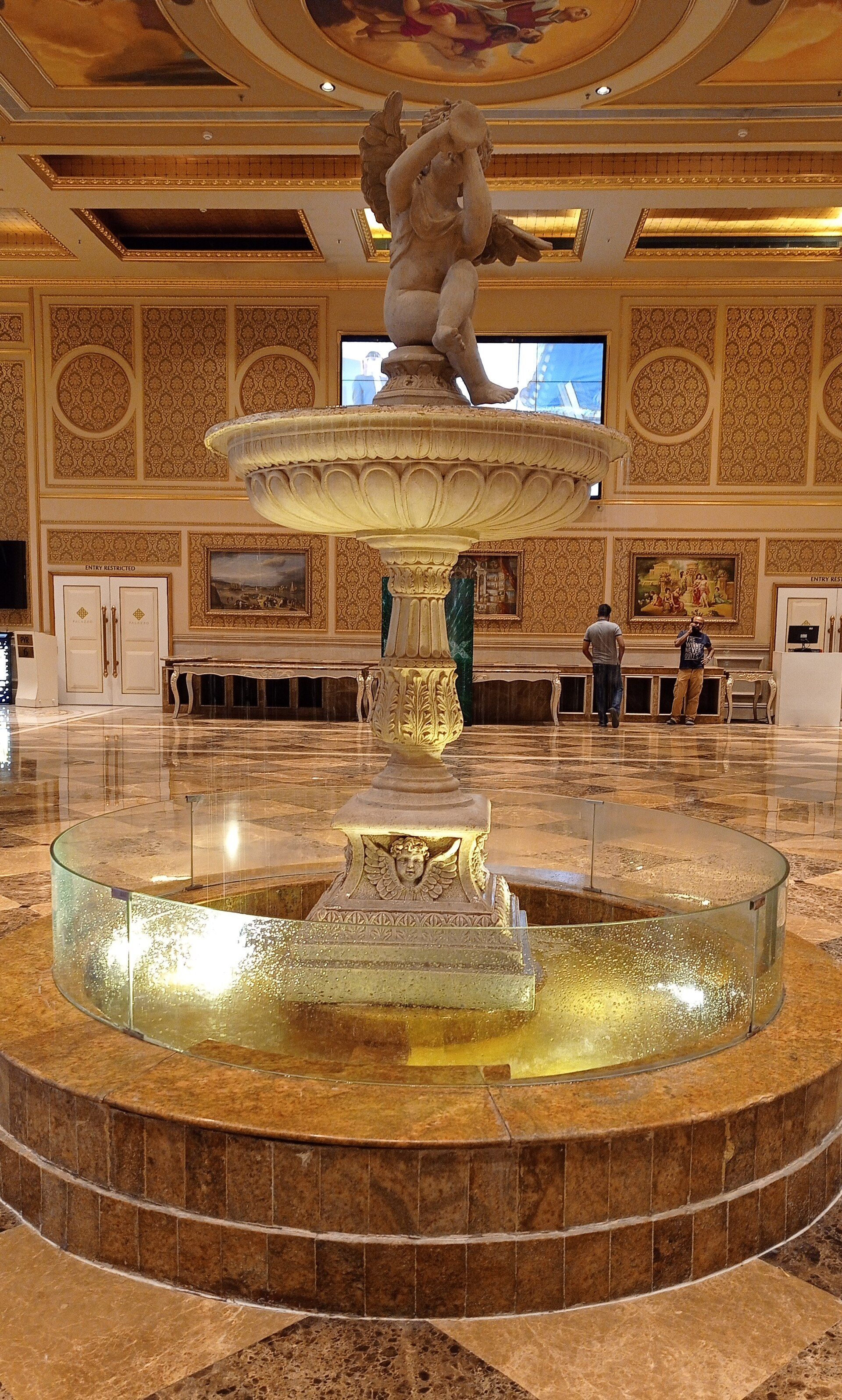 The marble atrium of a Chennai shopping mall with a fountain at its centre