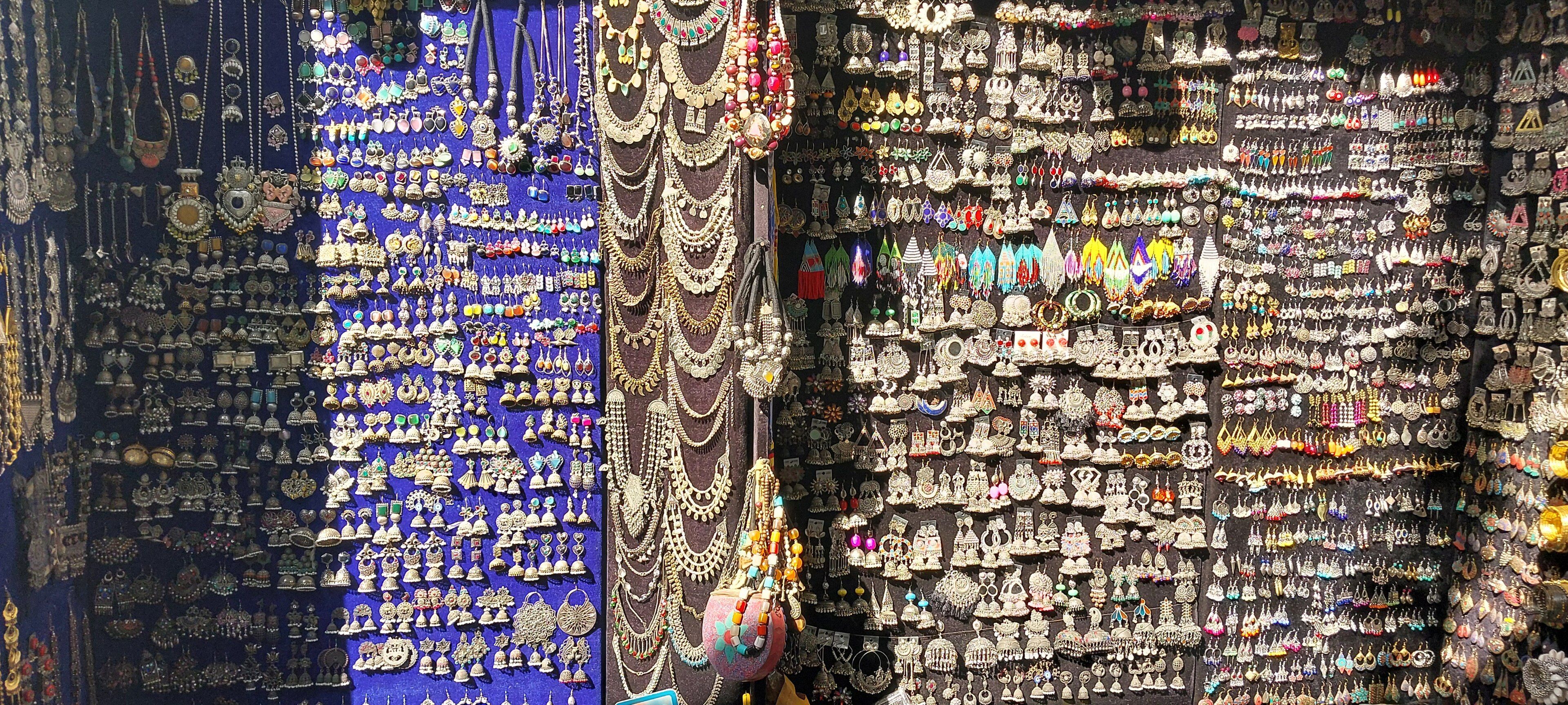 A wall of silver jhumkas, earrings and necklaces on display